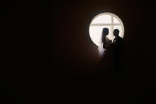 Silhouette Of A Bride And Groom On The Background Of The Window