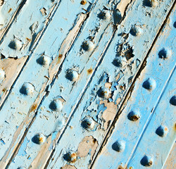 stripped paint in the blue wood door and rusty nail