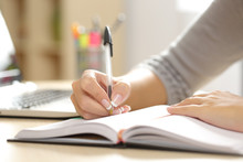 Woman Hand Writing In An Agenda At Home
