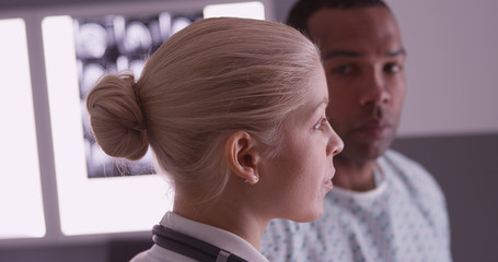 Wall Mural - Woman doctor explaining xrays to black patient