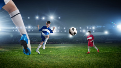 Kids play soccer on stadium 