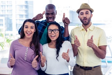 Wall Mural - Portrait of creative business people with thumbs up