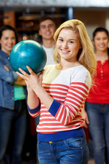 Poster - happy young woman holding ball in bowling club