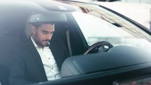 Businessman Using Tablet While Sitting Inside An Executive Black Car. Shot On RED Cinema Camera.