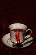 A vampire's tea cup with blood running down the side; textured image