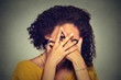 © pathdoc - Shy woman hiding face timid. Woman peeking though hands. Gray background.