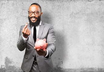 Wall Mural - business black man saving with a piggy bank