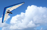 Hang Glider – Hang Glider flying through the sky white puffy clouds