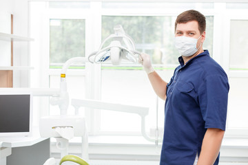 Attractive young dental doctor is working in his cabinet