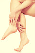 © Piotr Marcinski - Woman massaging her legs.