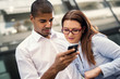 © Dusan Petkovic - Business people. Black man holding smart phone and typing massage, while his colleague looking at mobile phone. Shallow depth of field.