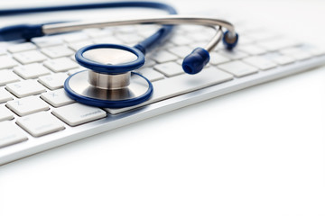 Stethoscope on computer keyboard on white background