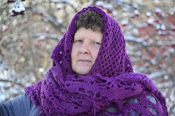 Wall Mural -  elderly woman in  purple knitted shawl on her head is about Rowan