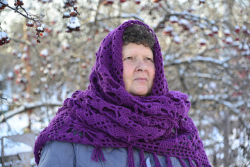 Wall Mural -  elderly woman in  purple knitted shawl on her head is about Rowan