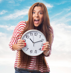 portrait of a beautiful young woman holding a big clock