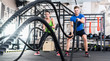 © Kzenon - Frau und Mann im Fitnessstudio mit battle rope