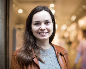 Wall Mural - Excited  brunette posing in clothing store and smiling