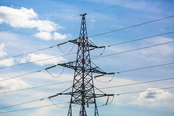 Wall Mural - Electricity pylon silhouetted against blue sky background. High voltage tower.