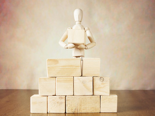 Wall Mural - Man building a wall of big blocks. Conceptual image with wooden puppet