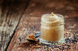 Freshly prepared mustard sauce in a small glass jar with a spoon