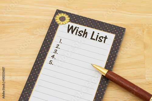 Photographie Un bloc-notes et un stylo sur un bureau avec le texte Wish List et copy-space