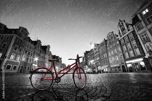 Plakat na zamówienie Vintage red bike on cobblestone historic old town in rain. Wroclaw, Poland.