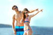 © Africa Studio - Happy couple pointing at the beach, outdoors