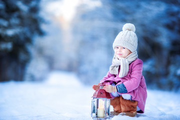 Wall Mural - Adorable little girl with flashlight in frozen forest on Christmas outdoors