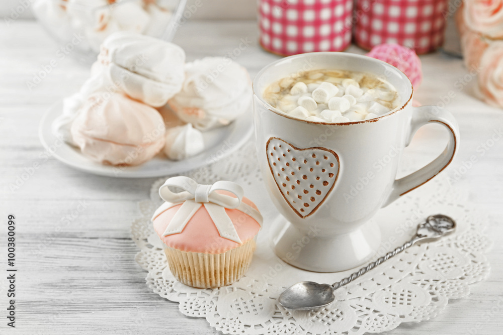 Mug of hot chocolate with marshmallows, on light wooden background