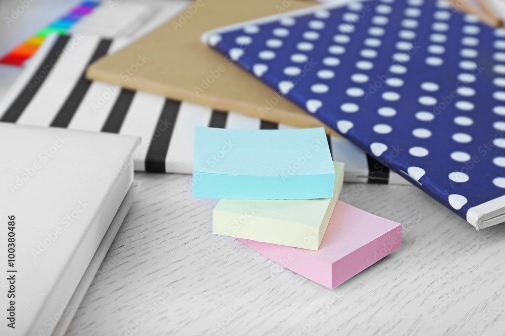 Notebooks with coloured stickers on a white table