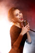 © Africa Studio - Elegant woman singing in colourful smoke, close up