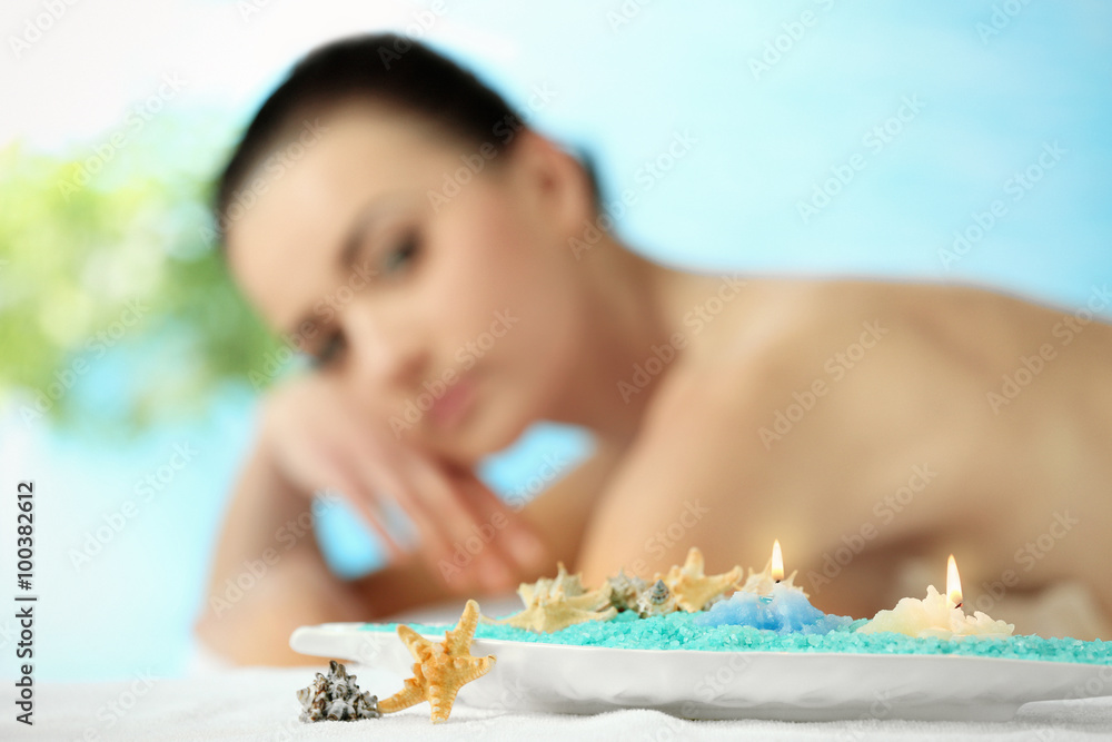 Spa concept. Young pretty woman relaxing on blue background, close up