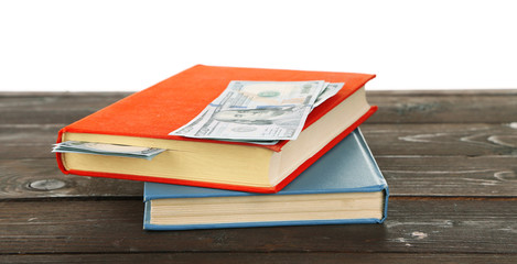 Books with nested dollar banknotes on white background. Stash of money