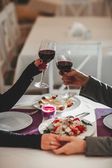 Wall Mural - Beautiful young couple with glasses of red wine in luxury restaurant