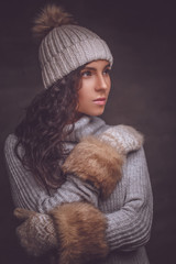 Wall Mural - Portrait of brunette woman in winter sweater and hat.