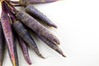 Bunch of heirloom purple carrots, over white and wooden backgrou