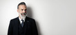 © SFIO CRACHO - Portrait of bearded gentleman wearing trendy suit and smiling against the empty wall. Wide