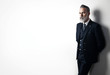 © SFIO CRACHO - Portrait of bearded businessman wearing trendy suit and stands against the empty white wall. Wide.