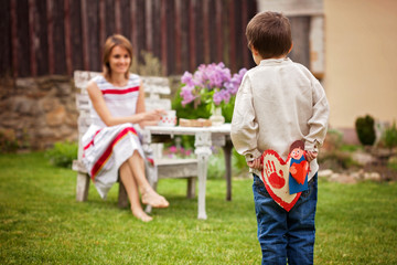 Poster - Beautiful mom, having coffee in a backyard, young cute child giv