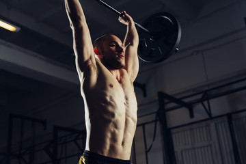 Wall Mural - Closeup of young man lifting barbells at gym