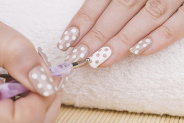 Manicure - Beauty treatment photo of nice manicured woman fingernails. Very nice feminine nail art with nice nude and white nail polish.