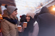 Young couple drinking hot beverages at winter holidays