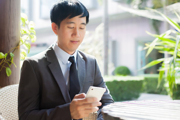 Asian businessman using phone in outdoor