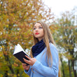 © ruslimonchyk - romantic dreamy girl reading a book outdoors.