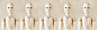 Wooden puppets as impersonal office staff stand in a row