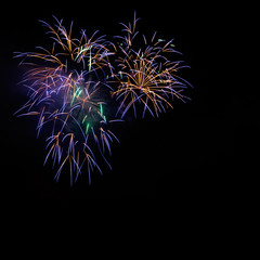 Beautiful golden, blue colorful celebration fireworks, salute with dazzling display in the night sky background, square. Fireworks explode in black background. 4 of July, Independence day, New Year