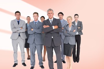 Composite image of business team standing arms crossed 