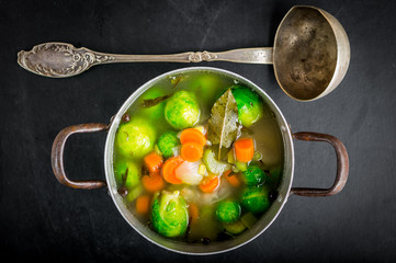 Brussels sprouts soup in a pot on black wooden table