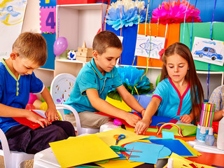 Wall Mural - Group kids of three people making colored paper on table in kindergarten .