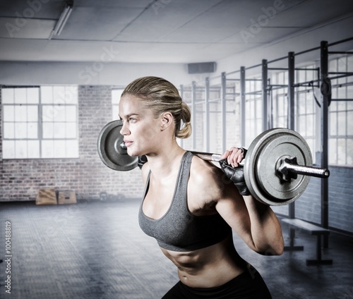 Naklejka na meble Composite image of muscular woman lifting heavy barbell 